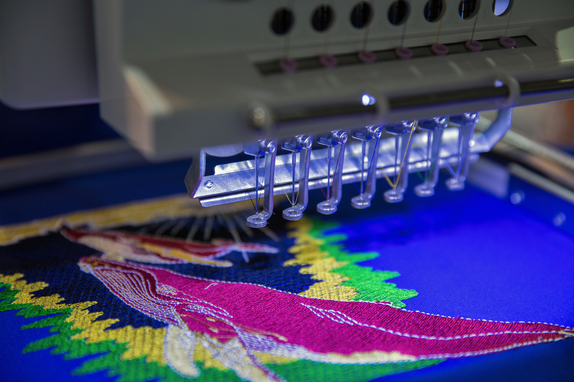 professional embroidery machine close up on needles and design